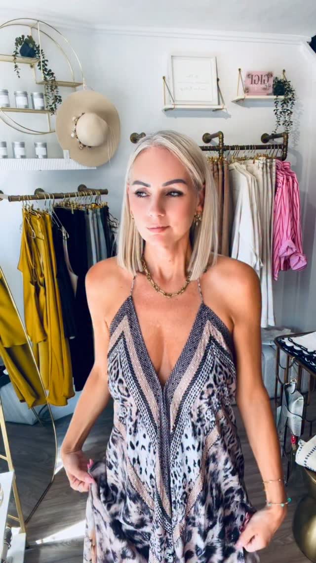 Gigi in the boutique wearing an animal print halterneck maxi dress